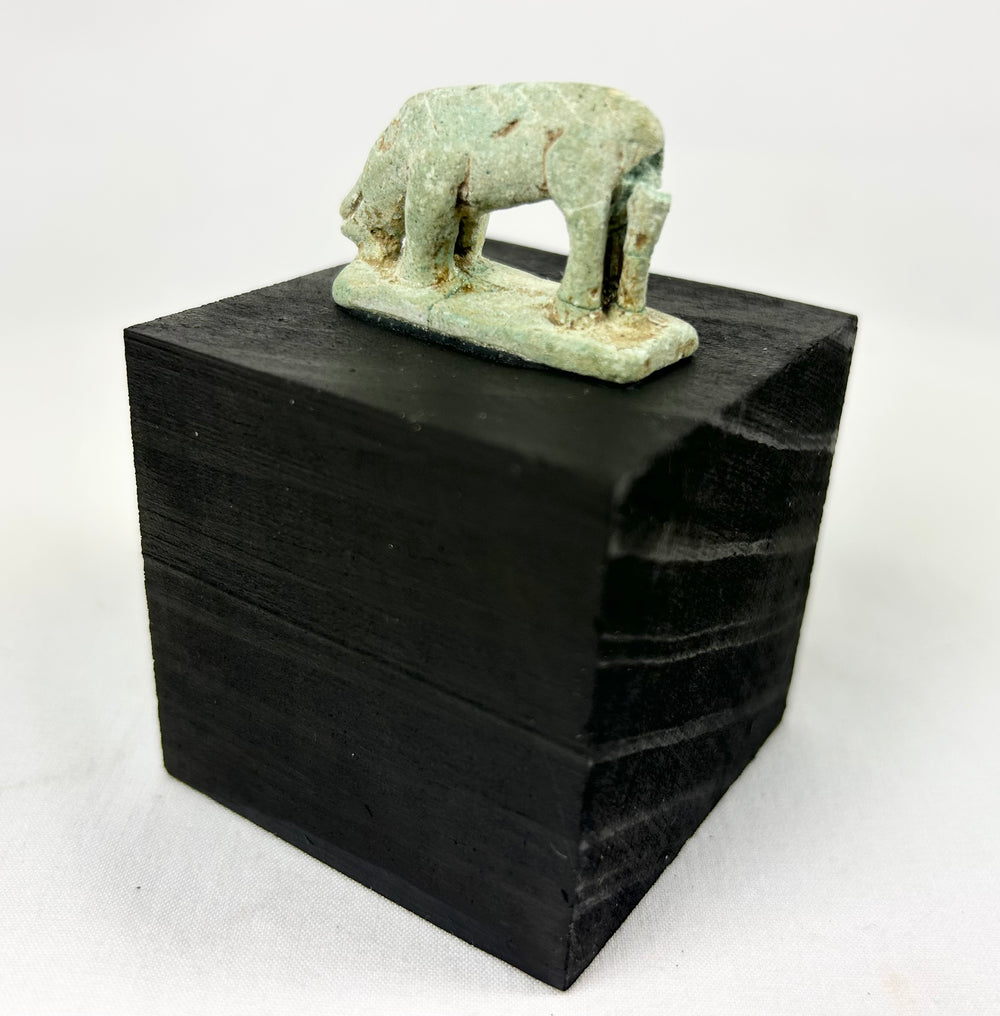 Ancient Egyptian protective shrew amulet, 664–30 BCE, pale green faience with burial wear.