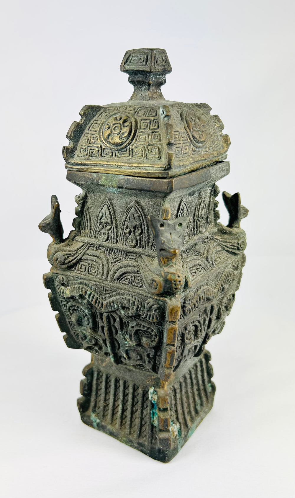 Archaistic Chinese ritual bronze with kui dragons and leiwen scrollwork, square form with stepped knop lid.