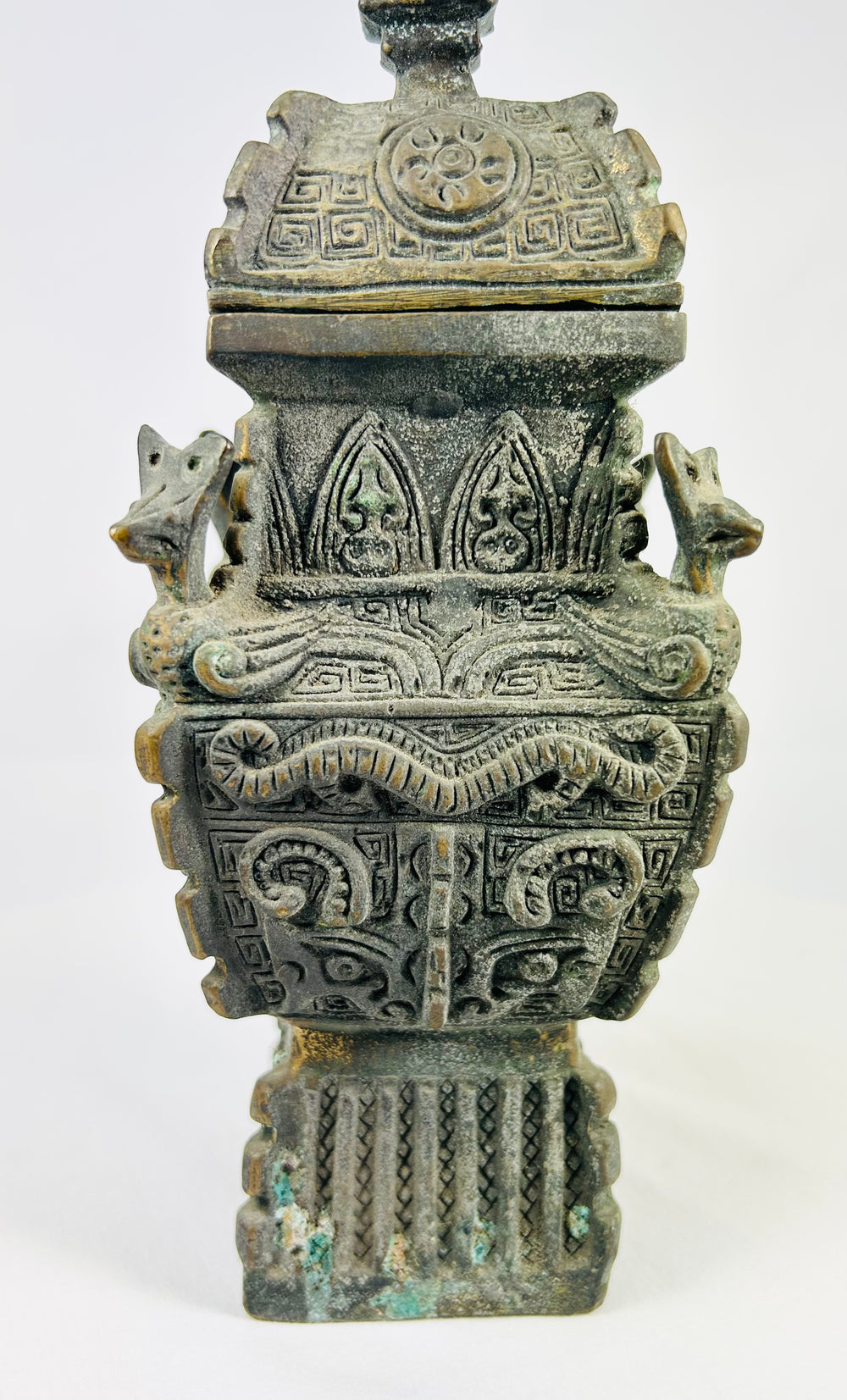 Late 19th century Chinese fang yi bronze, taotie masks in relief with malachite encrustation and integral pedestal foot.