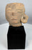 Authentic Pre-Columbian terracotta sculpture fragment from ancient Mesoamerica displayed on a stand.