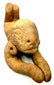 Ancient Pre-Columbian anthropomorphic figure featuring an oversized rounded head, stylized facial characteristics, and pierced ear ornaments.