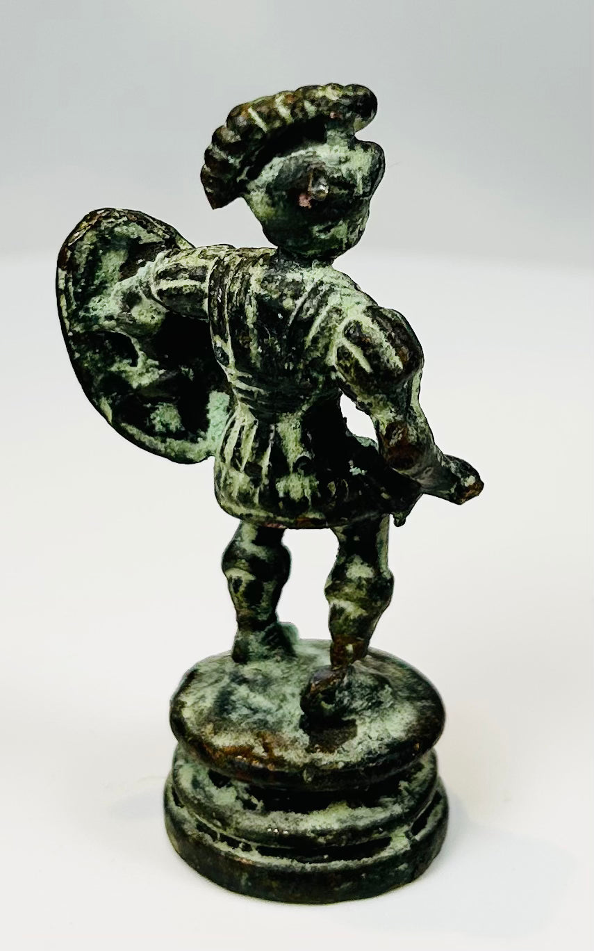 Antique bronze soldier figure with round shield and short tunic