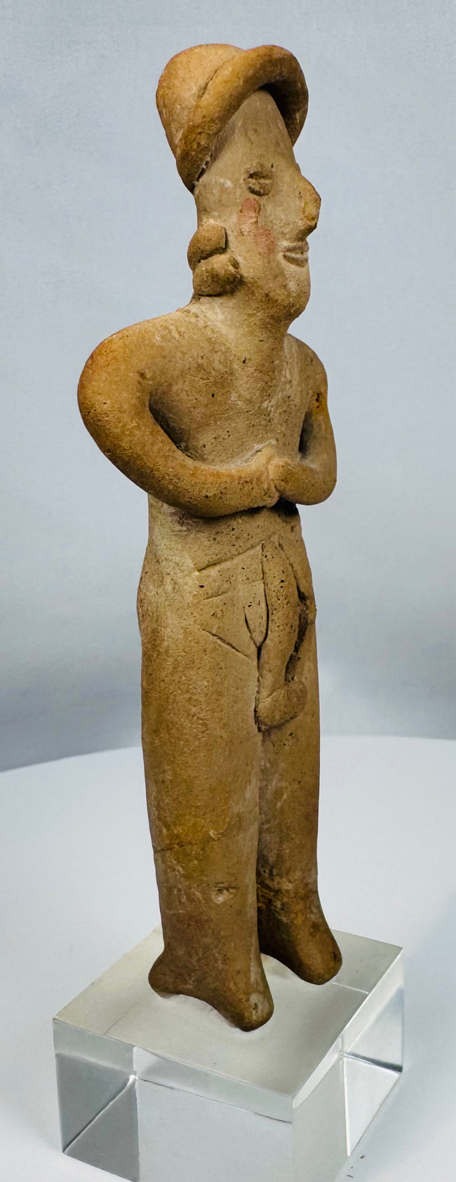 Ancient terracotta female effigy from Colima culture mounted for display on a custom lucite stand.