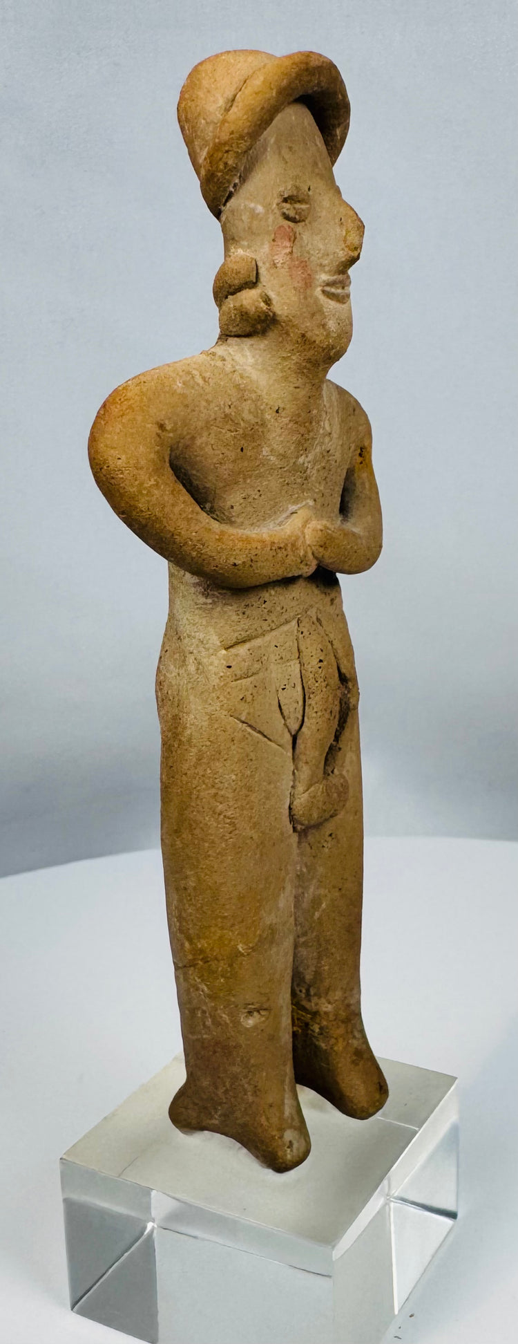 Ancient terracotta female effigy from Colima culture mounted for display on a custom lucite stand.