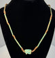 Egyptian Wedjat amulet necklace featuring a turquoise-green Eye of Horus pendant with raised protective symbolism and aged faience glaze.