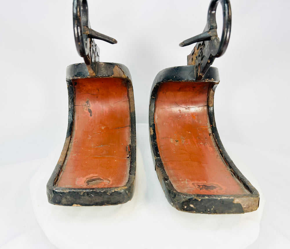 Pair of antique Japanese lacquered samurai stirrups with red interiors and black lacquered exteriors, Edo–Meiji period design, displayed on a white background.