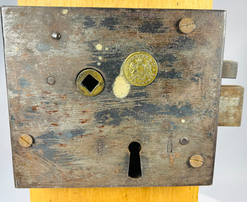 19th century iron rim lock mechanism with maker medallion and display stand