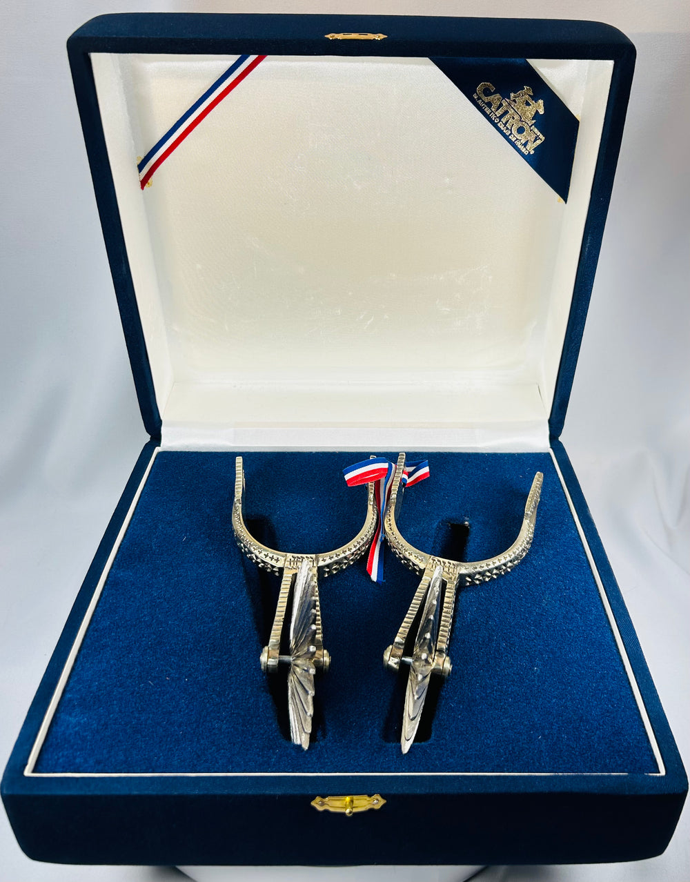 Traditional Chilean espuelas with engraved design and blue velvet display case