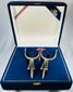Traditional Chilean espuelas with engraved design and blue velvet display case