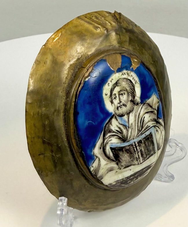 Russian Orthodox religious enamel icon with a haloed Evangelist, vivid cobalt-blue background, and aged oval copper-alloy surround.