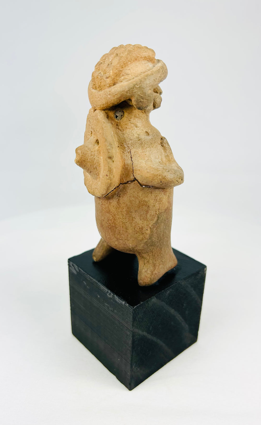 Pre-Columbian terracotta effigy with circular back disk, hand-modeled, 100 BCE–300 CE, museum-style mount