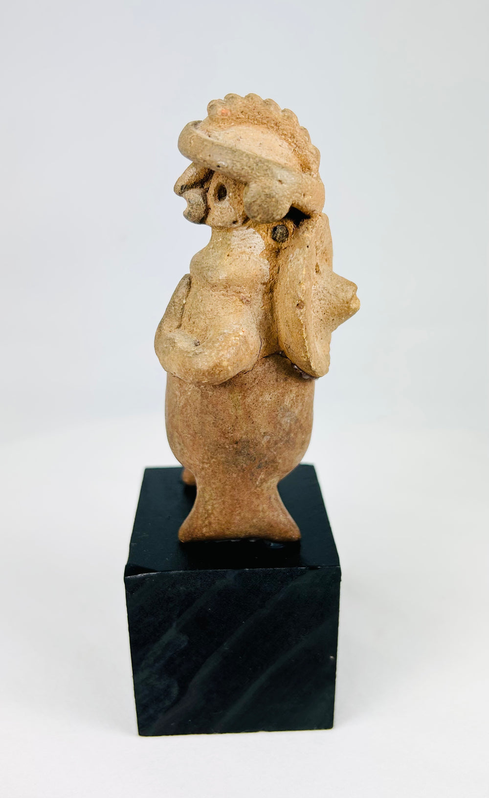 Mounted West Mexican terracotta effigy, Jalisco/Nayarit, standing warrior figure, perforated back disk, mineral traces