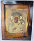Black Madonna devotional icon with embossed metal revetment, jeweled crowns, and decorative halo motifs.