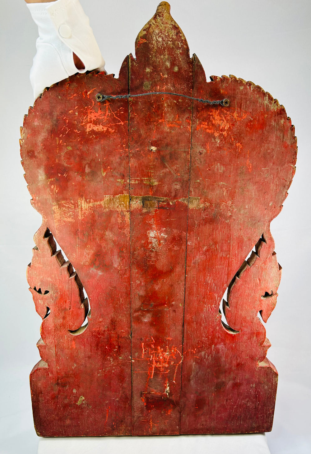 Gold leaf and red lacquer Thai temple panel with carved naga serpents, dharmachakra symbol, foliate aureole, and kranok flame crest, late 1800s.