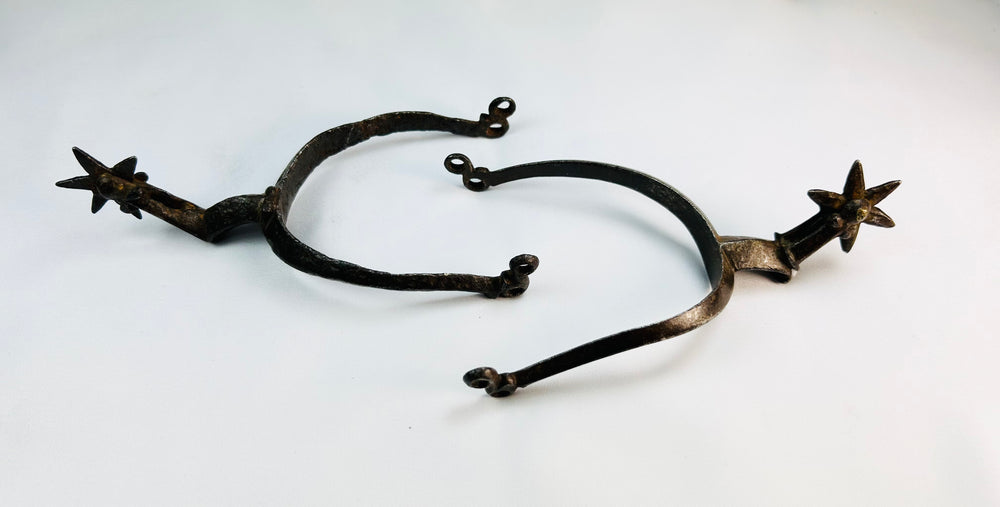 Antique German riding spurs with six-point rowels shown side by side