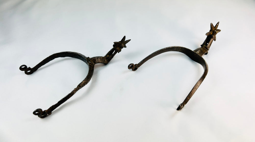 Museum-quality Saxon iron spurs with pointed rowels photographed on white