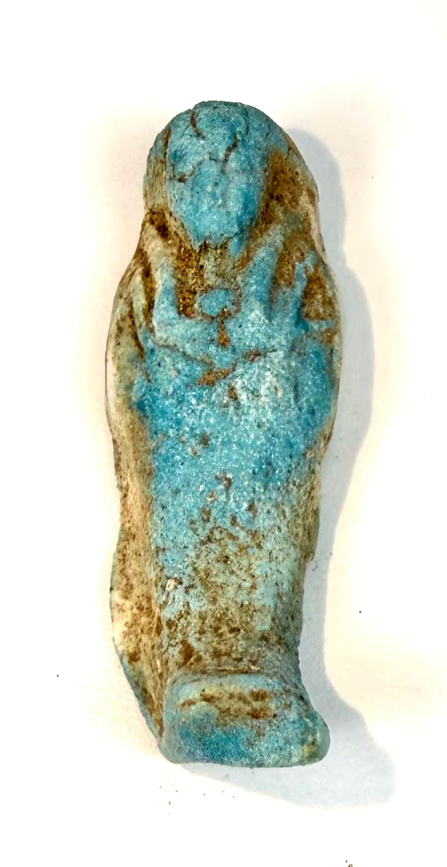 Ancient Egyptian turquoise faience shabti with traditional funerary styling, an elongated body, and areas of exposed cream-coloured material.