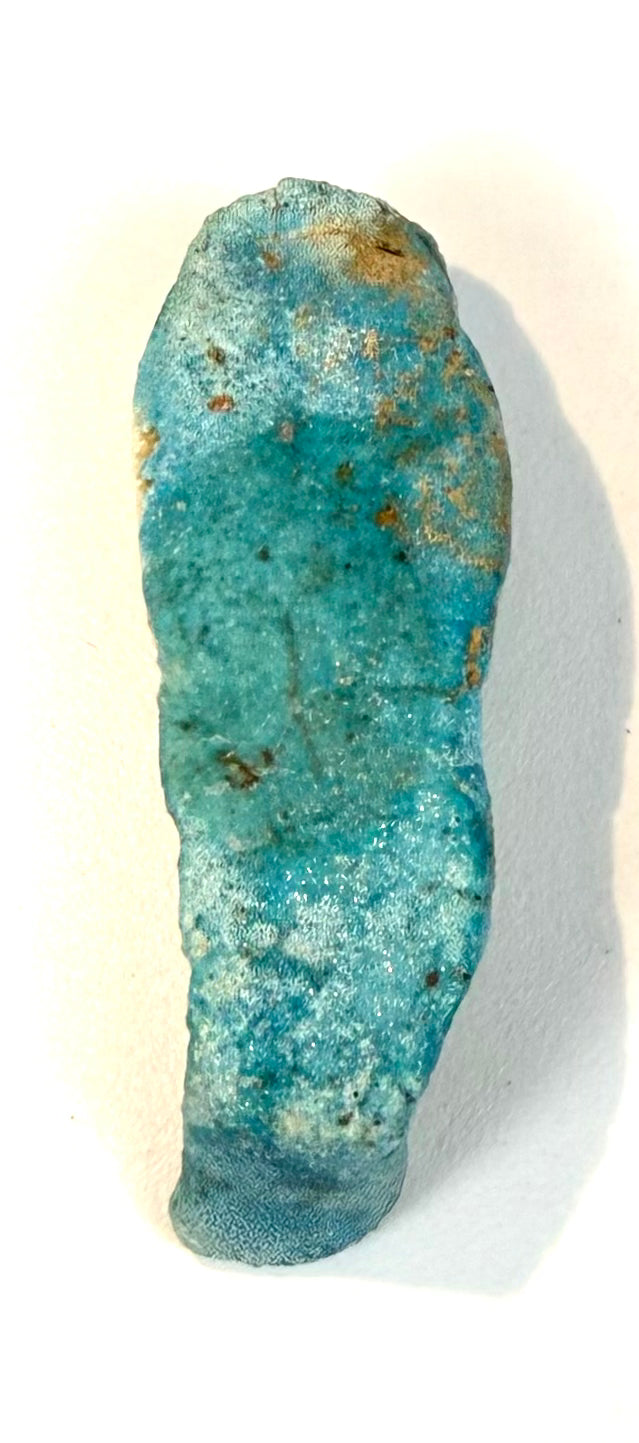 Ancient Egyptian Late Period–Ptolemaic ushabti figure featuring turquoise-blue glaze, a rounded head, traditional crossed arms, and archaeological surface wear.