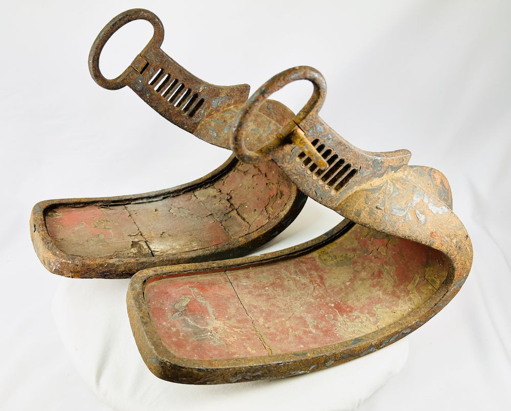 Pair of antique Japanese abumi stirrups used by samurai cavalry, with large suspension rings and sculptural iron construction.