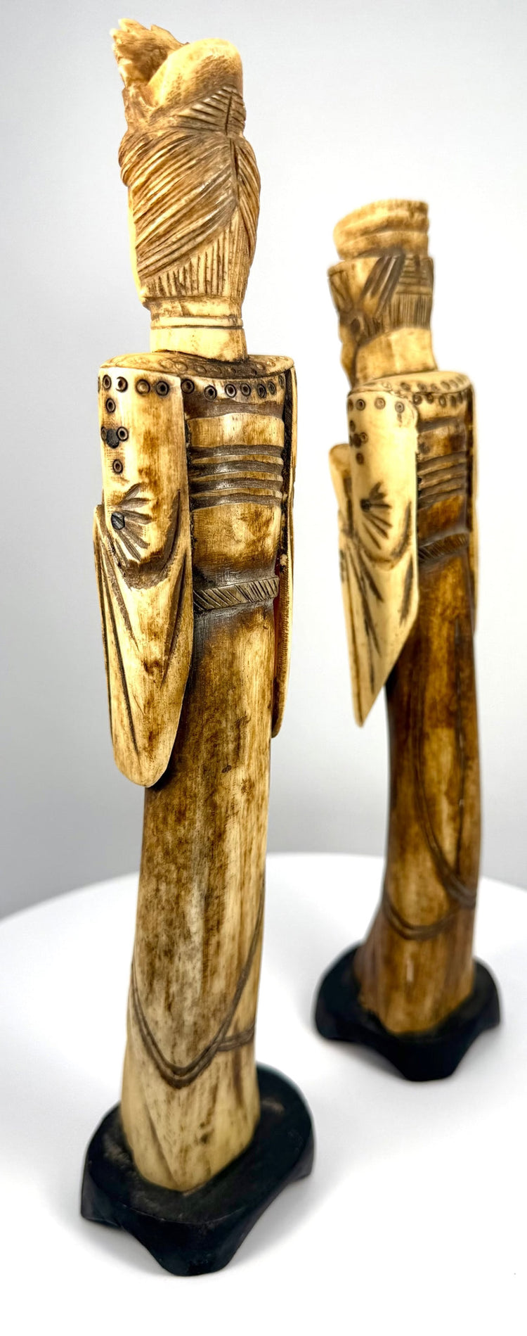 Chinese carved-bone Emperor and Empress figurines featuring detailed hands, ceremonial-style accessories, and intricately patterned garments.