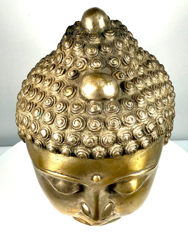 Golden copper-alloy Buddha head featuring detailed ear modelling, carefully sculpted hair curls, and a cylindrical neck base with horizontal incised bands.