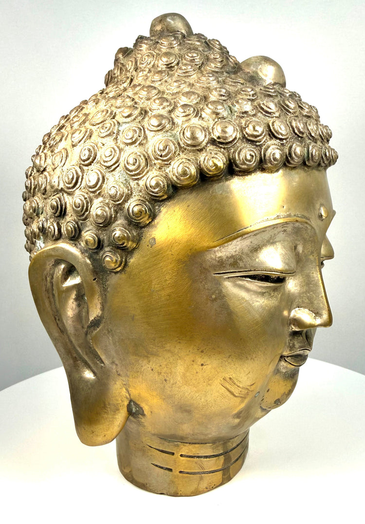 Vintage Buddhist Buddha head featuring elongated earlobes, finely defined facial contours, and naturally darkened patination around the ears and hair.