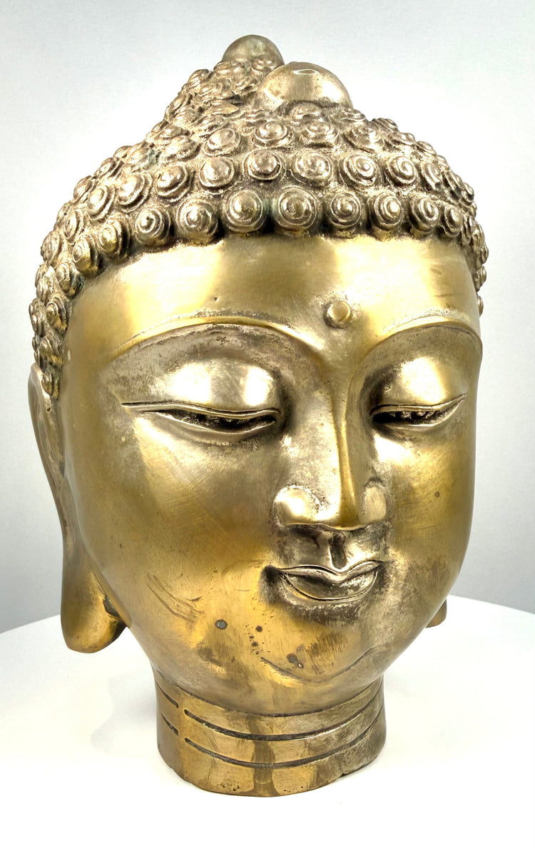 Cast copper-alloy Buddha sculpture displaying intricately modelled spiral curls, a raised ushnisha, and traditional Buddhist religious iconography.