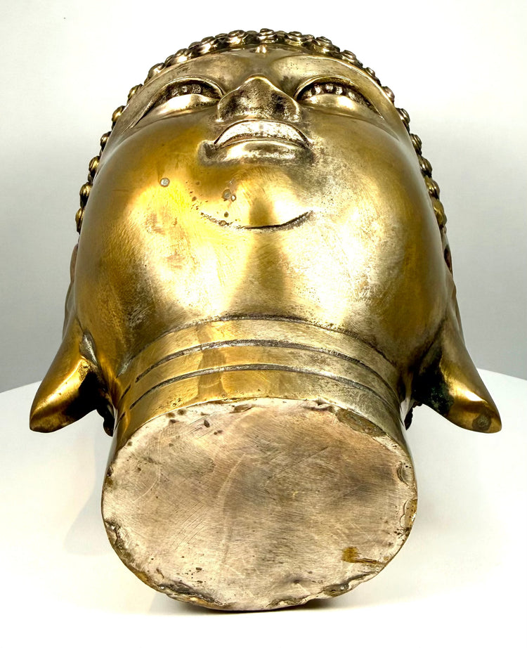 Mid-20th-century cast-metal Buddha head showing underside finishing marks, textured metal surfaces, cylindrical neck construction, and aged golden patination.