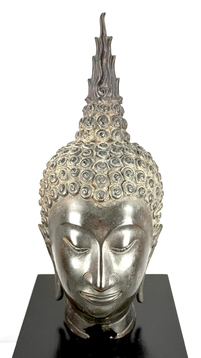 Cast copper-alloy Buddha head featuring gracefully arched eyebrows, a prominent nose, and delicately sculpted facial contours.