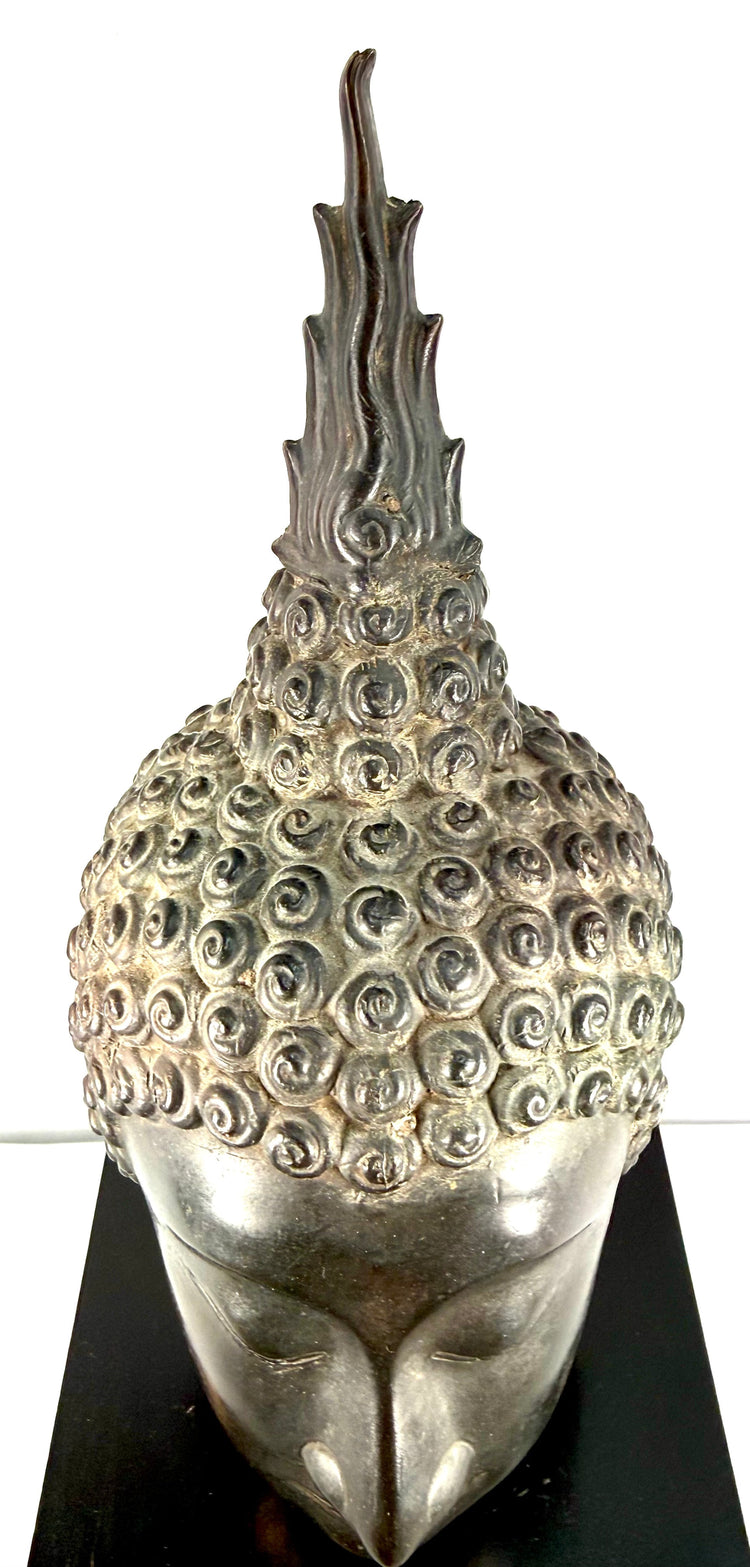 Tall flame finial on a Thai Buddha head, decorated with flowing vertical ridges symbolizing spiritual enlightenment.