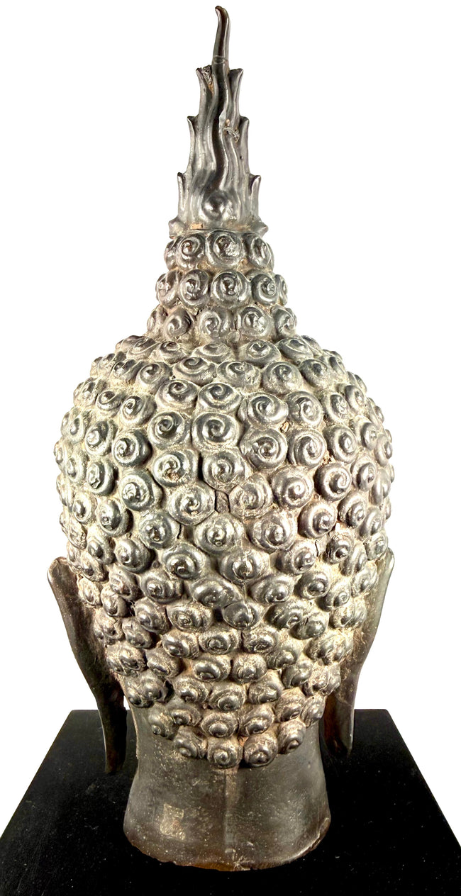Large cast metal Buddha head featuring softly rounded cheeks, a sculpted chin, and harmonious Sukhothai-style proportions.