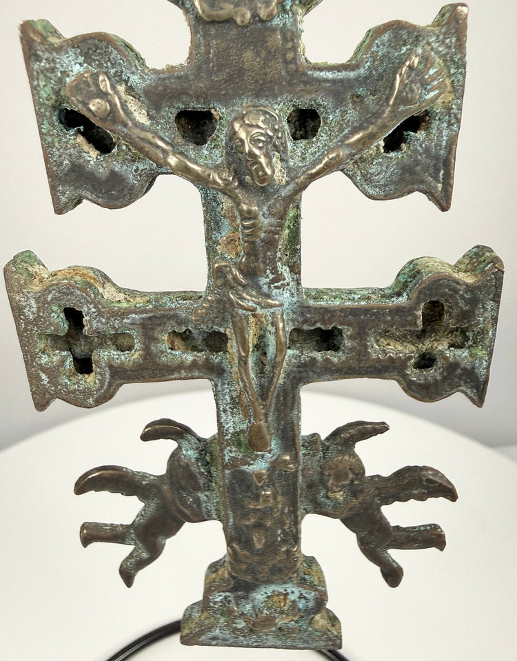 Spanish bronze devotional pendant with an elongated suspension loop, raised Christian figures, and intricate ornamentation along the central shaft.