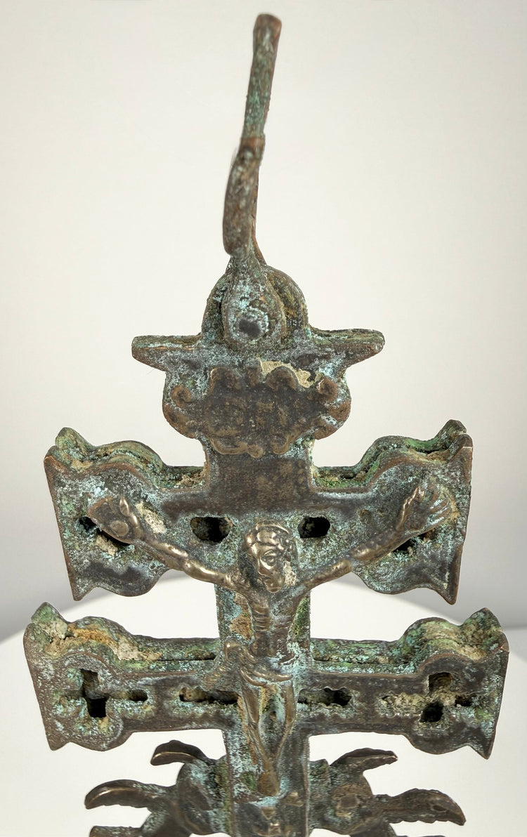 Antique Caravaca crucifix displaying the Virgin Mary beneath the Crucifixion, surrounded by decorative relief and aged bronze patination.