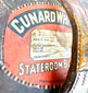 Early 20th-century leather top hat travelling case featuring an oval construction, stitched panels, and aged brown leather.