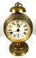 Early 20th-century Jahresuhrenfabrik alarm clock from Triberg, Germany, with decorative brass housing and an elevated pedestal base.