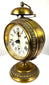 German Black Forest mechanical alarm clock displaying a cream-coloured dial, bold Roman numerals, and traditional black metal hands.