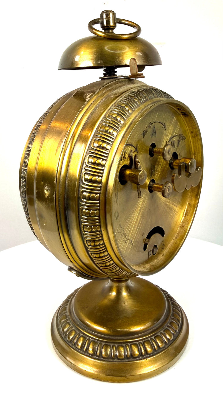 Antique JUF brass clock featuring two subsidiary registers for alarm setting and seconds beneath its ornate circular housing.