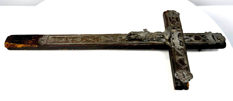 Eighteenth-century French folk-art crucifix with pierced lead decorations, raised religious emblems, and ornamental metal borders.
