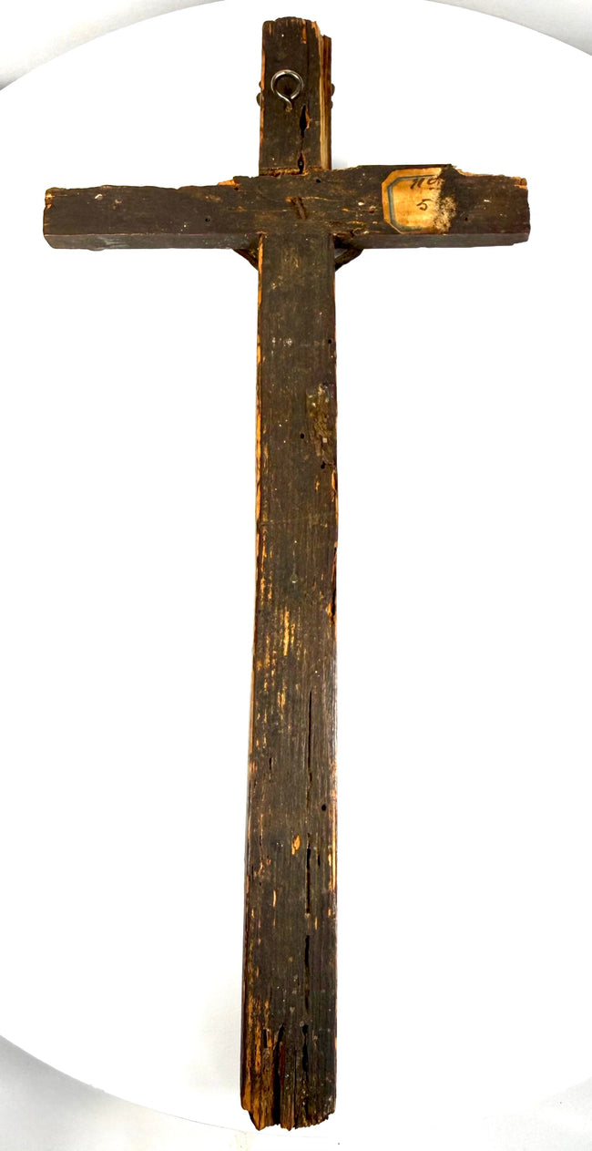 Dark-painted pine wood of an antique French peddler’s cross showing historic surface wear, exposed wood grain, and aged patina.