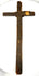 Dark-painted pine wood of an antique French peddler’s cross showing historic surface wear, exposed wood grain, and aged patina.