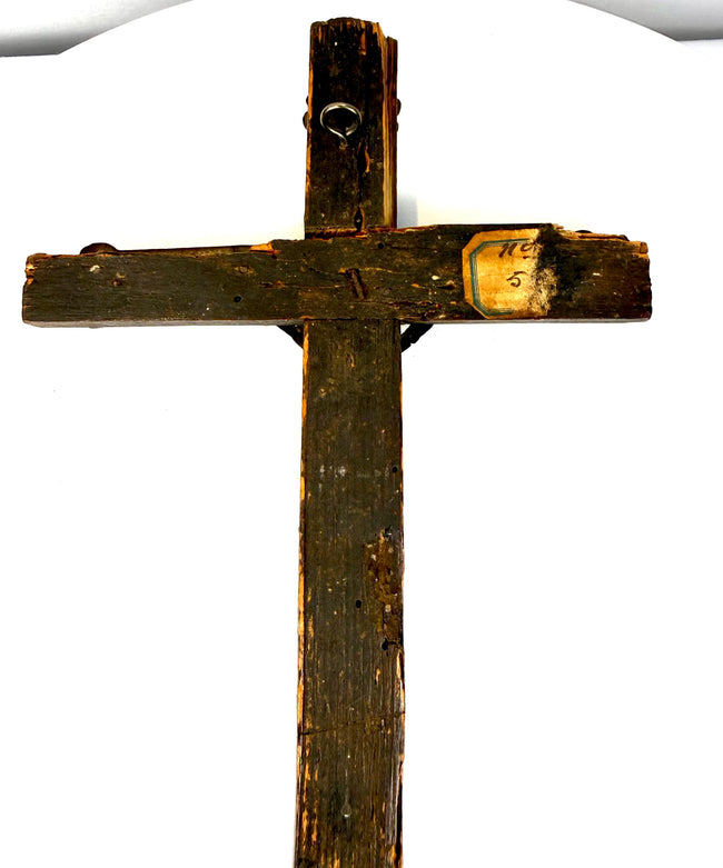Reverse of an 18th-century French wooden crucifix featuring an aged wooden surface and metal suspension loop for wall display.