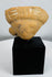 Terracotta human effigy head fragment mounted for display, retaining traces of original white pigment.