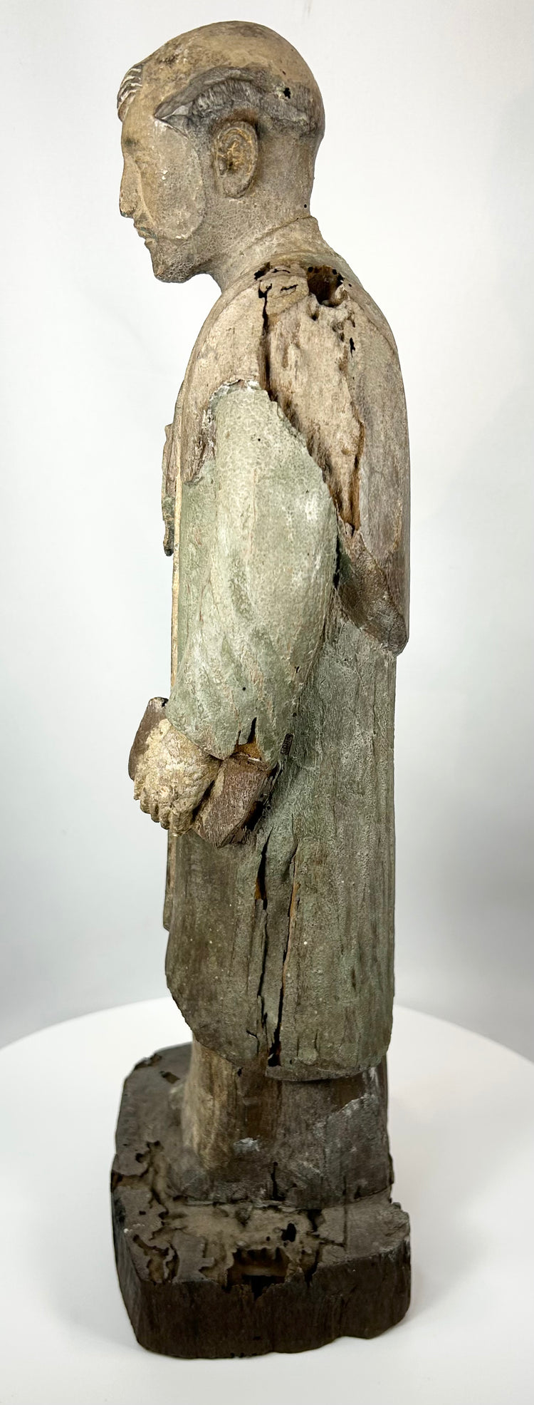 Wooden santo statue with remnants of green and cream polychrome pigment
