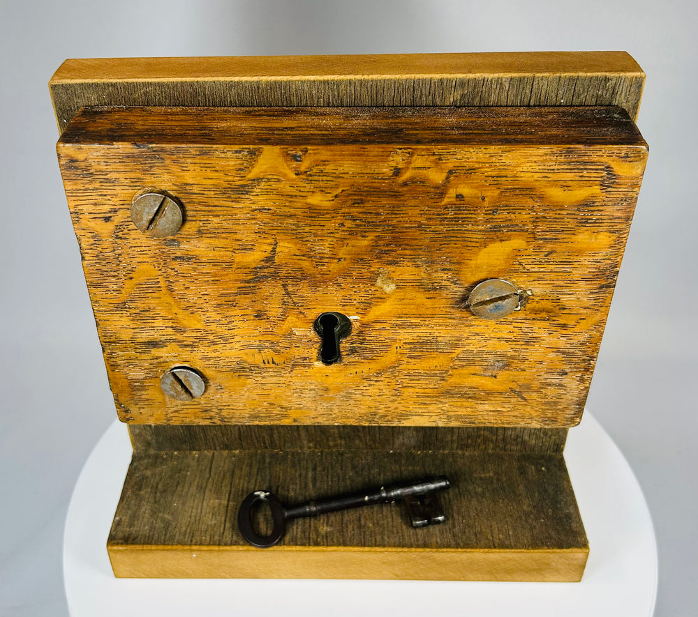 Antique wood and iron lock mechanism mounted for display with original key