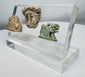 Faience Hathor amulet accompanied by carved stone lion and classical portrait fragment from antiquity.