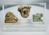 Ancient Egyptian and Greco-Roman antiquities mounted in a clear display case featuring religious and figural carvings.