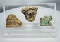 Ancient Egyptian and Greco-Roman antiquities mounted in a clear display case featuring religious and figural carvings.