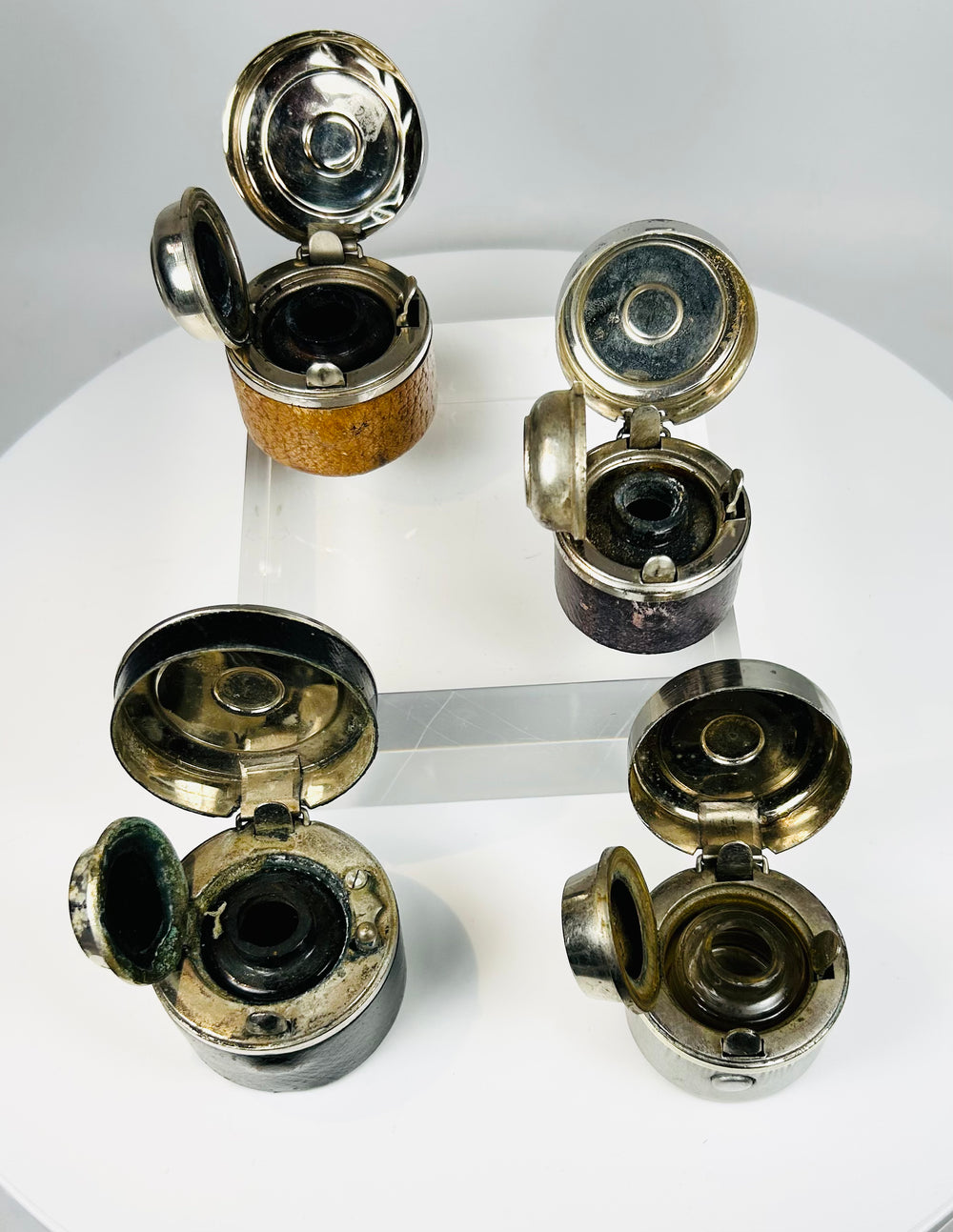 Old portable inkwells with worn leather covering and functional lids