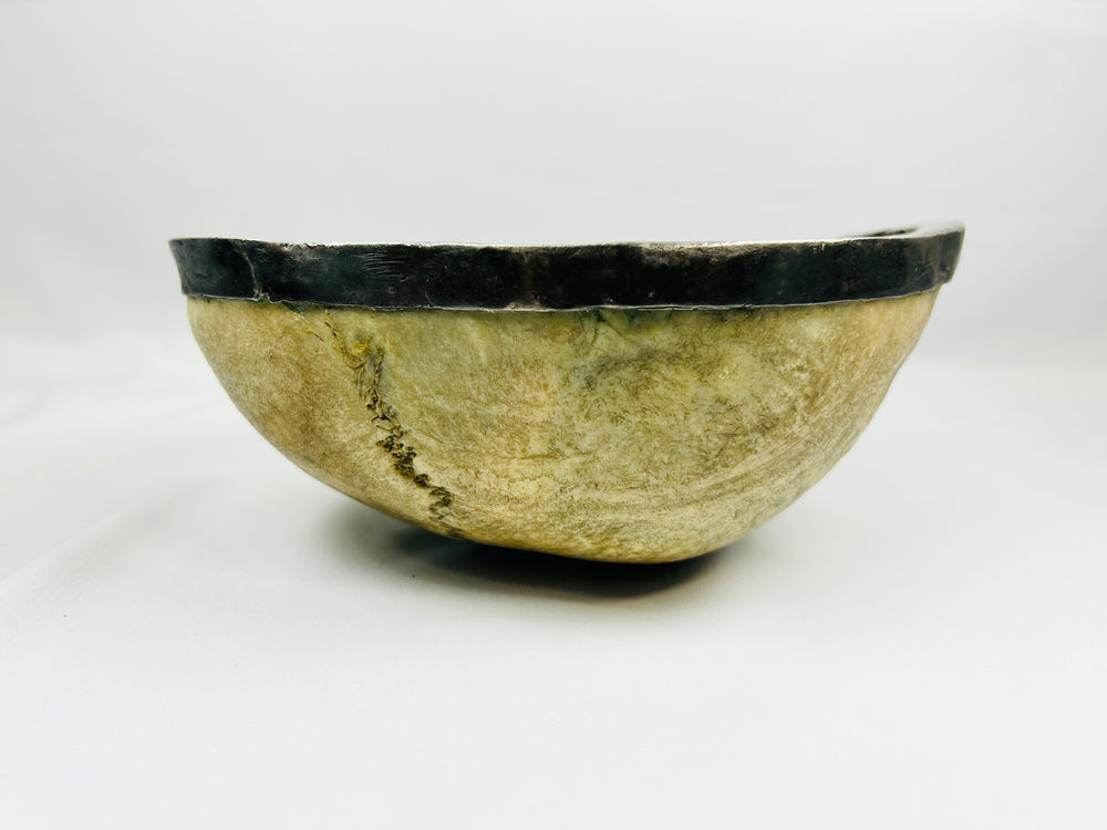 Side view of Tibetan Kapala ritual skull cup with polished human bone and silver rim, used in Tantric Buddhist ceremonies, 19th century