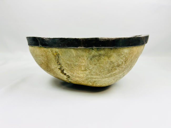 Side view of Tibetan Kapala ritual skull cup with polished human bone and silver rim, used in Tantric Buddhist ceremonies, 19th century